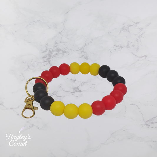 Colorful beaded keychain with gold clasp on a marble background with 'Hayley's Comet' branding.